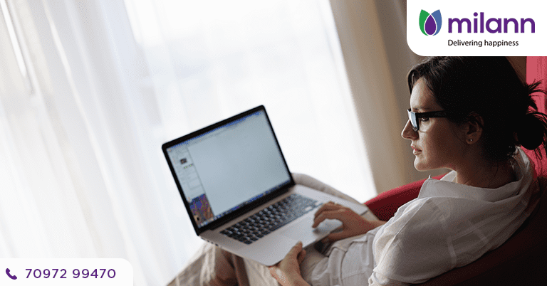 A woman sitting with her laptop on reflecting on hysteroscopy check.